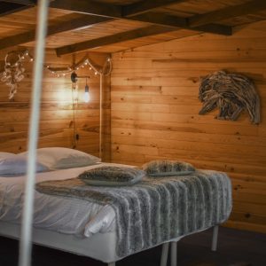 Chalet en bois chaleureux avec lit douillet et décor naturel dans les Hauts-de-France.