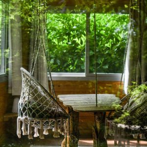 Hébergement insolite en Hauts-de-France avec chaises suspendues et vue verdoyante.