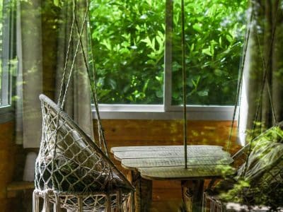 Hébergement insolite en Hauts-de-France avec chaises suspendues et vue verdoyante.