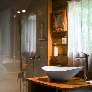 Salle de bain dun hébergement insolite en bois, avec un lavabo moderne et lumineux.