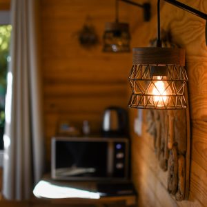 Cabane en bois chaleureuse avec lampes suspendues et décoration naturelle.