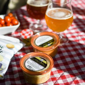 Dégustation conviviale avec bières et plats locaux dans un hébergement insolite.