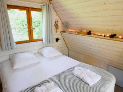 Chalet en bois chaleureux avec lit double et décoration naturelle.