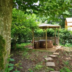 Hébergement insolite en Hauts-de-France avec un jacuzzi sous un abri en bois.