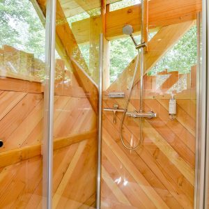 Douche en bois dans un hébergement insolite en Hauts-de-France, ambiance nature.