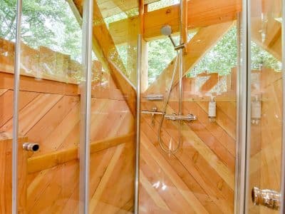 Douche en bois dans un hébergement insolite en Hauts-de-France, ambiance nature.