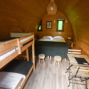 Hébergement insolite en bois avec lit superposé et décoration chaleureuse.