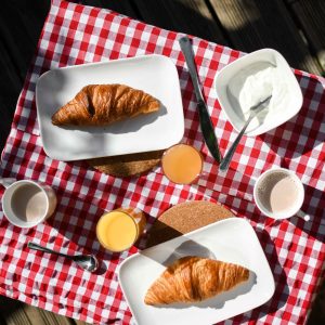 Petit-déjeuner en pleine nature dans un hébergement insolite, avec croissants et jus.