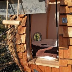 Hébergement insolite en forme de cabane en bois, avec une vue circulaire sur la nature.