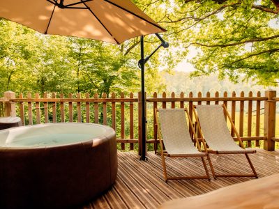 Hébergement insolite en Hauts-de-France avec jacuzzi et chaises longues sous un parasol.