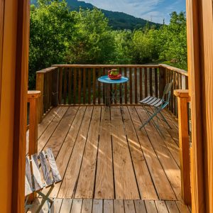 Cabane perchée en Auvergne-Rhône-Alpes avec terrasse en bois et vue sur la nature.