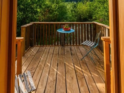 Cabane perchée en Auvergne-Rhône-Alpes avec terrasse en bois et vue sur la nature.