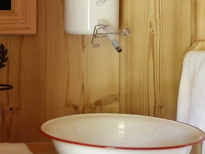 Hébergement insolite en bois avec lavabo vintage en émail et décor chaleureux.