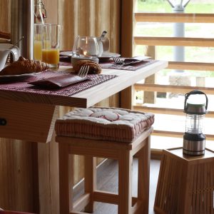 Hébergement insolite en bois dans le Grand-Est, avec une table décorée et des boissons.
