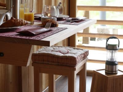 Hébergement insolite en bois dans le Grand-Est, avec une table décorée et des boissons.