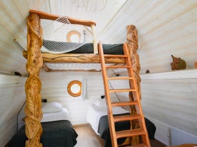 Cabane en bois avec mezzanine, éclairage naturel et décoration chaleureuse.