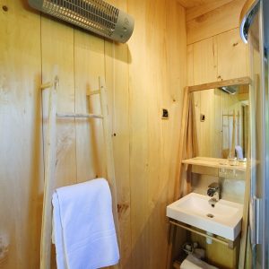 Hébergement insolite en Aquitaine : intérieur en bois chaleureux avec salle de bain moderne.