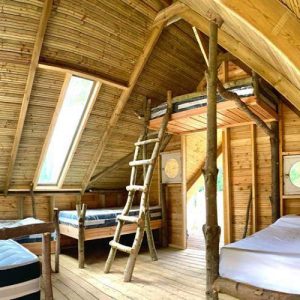 Cabane en bois à Basse-Normandie, avec un intérieur chaleureux et des lits en bois.