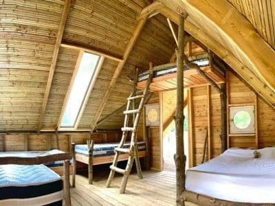 Cabane en bois à Basse-Normandie, avec un intérieur chaleureux et des lits en bois.