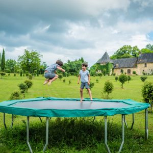 Hébergement insolite en Aquitaine : enfants samusant sur un trampoline dans un grand jardin.