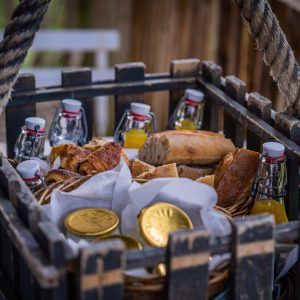 Panier gourmand dans un hébergement insolite en Aquitaine, avec viennoiseries et jus.