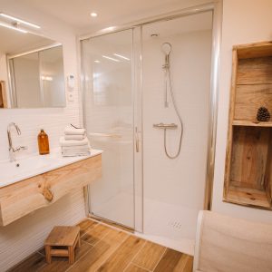 Salle de bain moderne dun hébergement insolite en Pays de la Loire, avec douche vitrée.