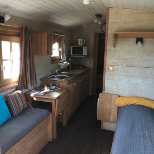 Hébergement insolite en Pays de la Loire : intérieur en bois chaleureux avec cuisine équipée.