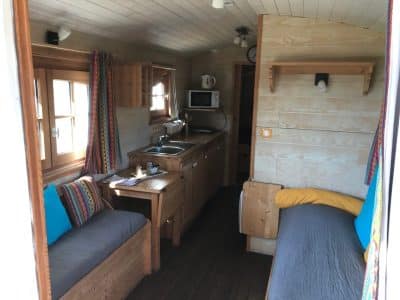 Hébergement insolite en Pays de la Loire : intérieur en bois chaleureux avec cuisine équipée.