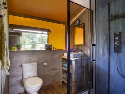 Salle de bain moderne dun hébergement insolite en Nouvelle-Aquitaine, avec douche spacieuse.
