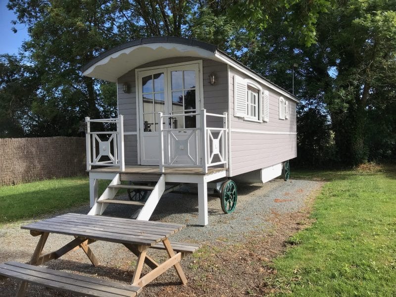 Charmante roulotte en bois avec terrasse, entourée de verdure à Pays de la Loire.