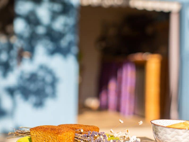 Gîte charmant avec un coin repas extérieur et des douceurs sur une table en bois.