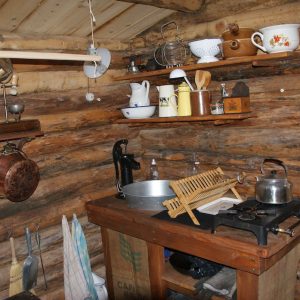 Cabane en bois en Auvergne-Rhône-Alpes, avec une cuisine rustique et des ustensiles vintage.