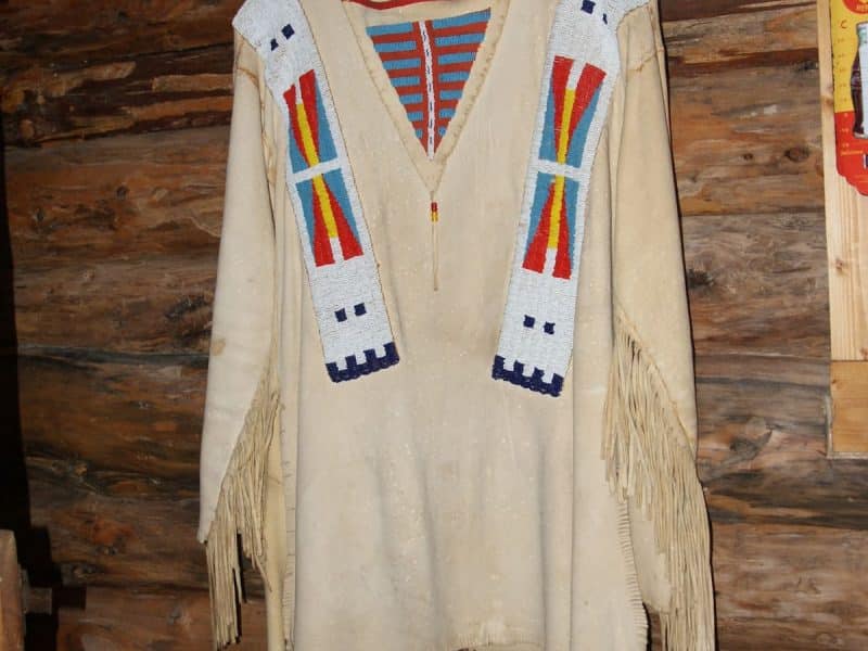 Hébergement en cabane en bois avec une tenue traditionnelle accrochée au mur.