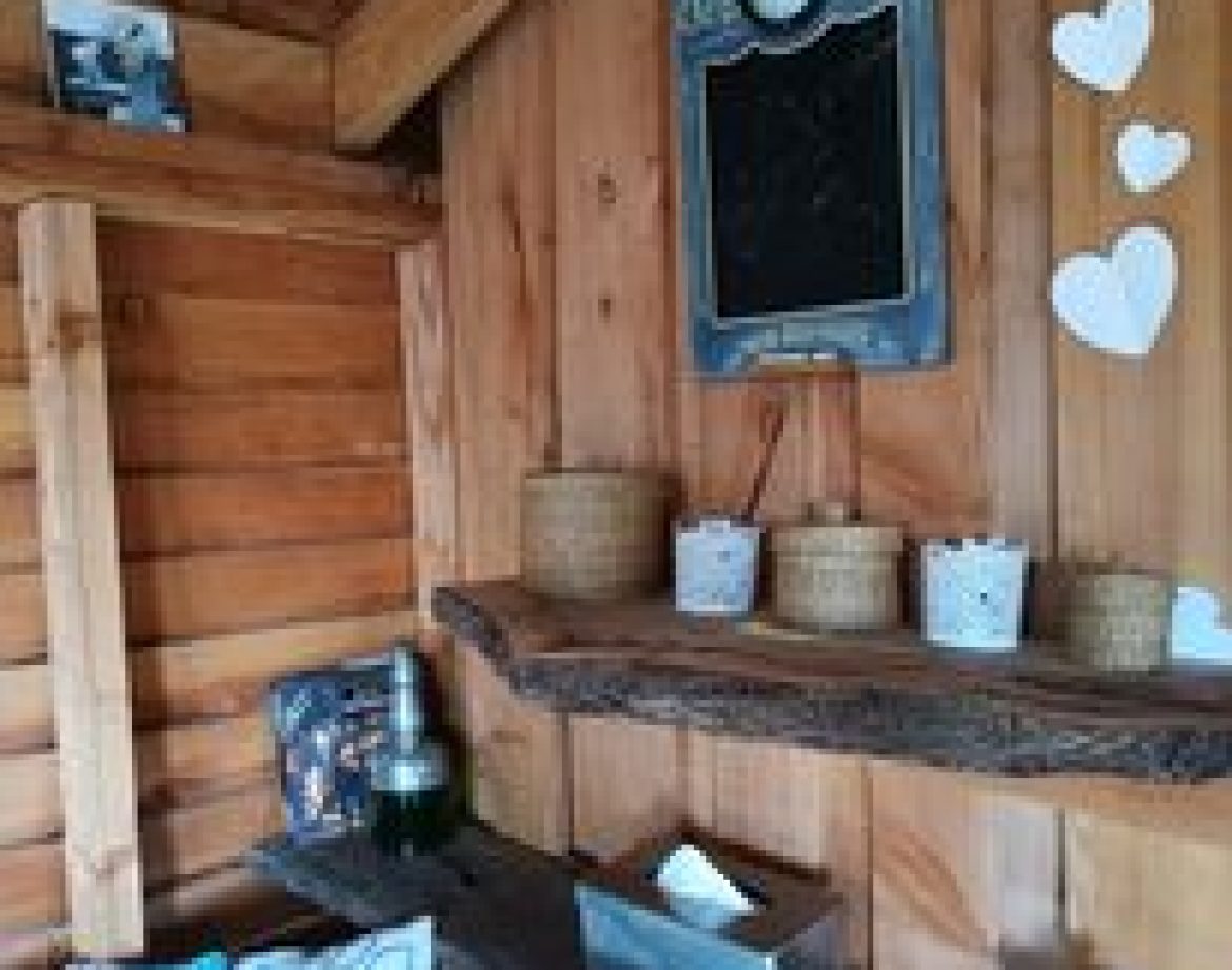 Cabane en bois cosy avec étagère rustique et décor en cœur.