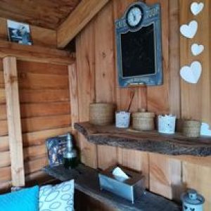 Cabane en bois cosy avec étagère rustique et décor en cœur.