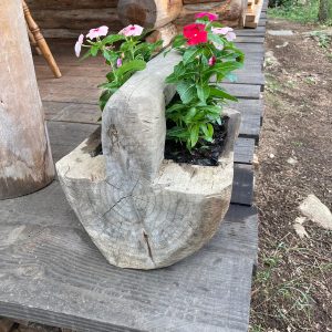 Hébergement insolite en Auvergne-Rhône-Alpes avec un pot de fleurs en bois rustique.