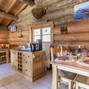 Chalet en bois chaleureux en Auvergne-Rhône-Alpes, avec tables en bois et vue montagne.