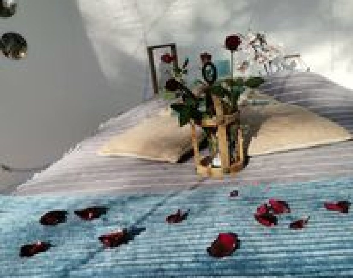 Hébergement insolite en Provence : chambre romantique décorée de roses et dun plaid bleu.