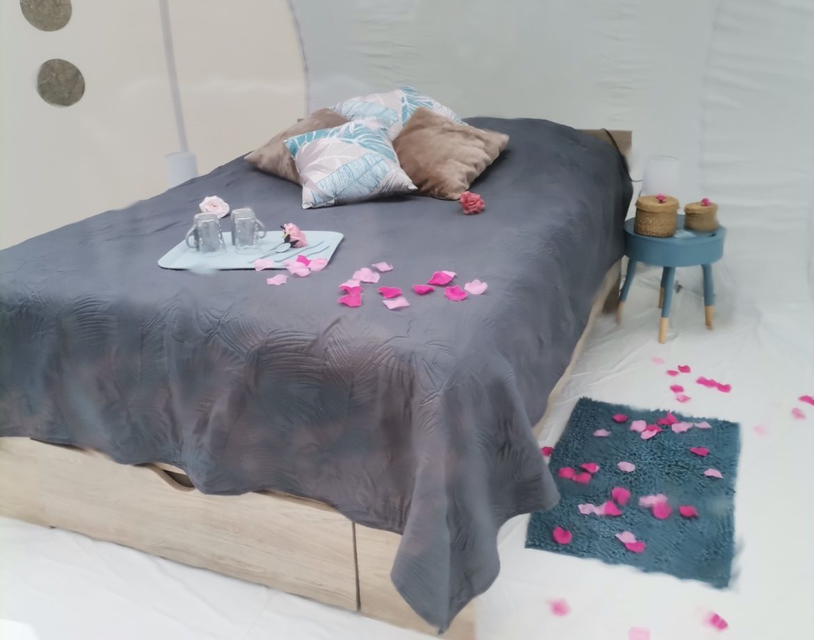 Hébergement insolite en bulle avec lit décoré de pétales de rose à Provence-Alpes-Côte dAzur.