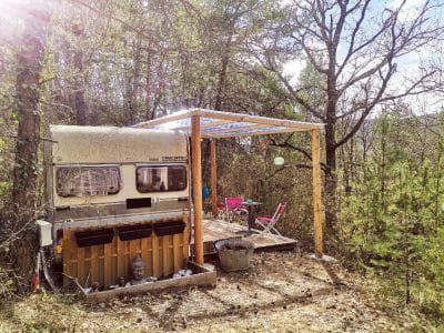 Caravane vintage sous un auvent, entourée de verdure en Provence-Alpes-Côte dAzur.