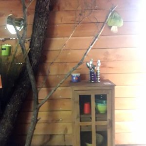 Cabane en bois avec un meuble rustique et des éléments naturels décoratifs.