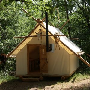 Tente lodge en bois, nichée dans la forêt, offrant un séjour unique en pleine nature.