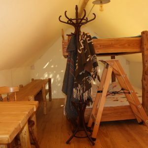 Chalet en bois avec lit superposé, table en bois et décor chaleureux en Auvergne-Rhône-Alpes.
