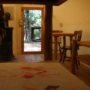 Tente lodge en Auvergne-Rhône-Alpes, avec vue sur la nature et mobilier en bois.