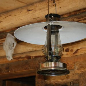 Lanterne vintage suspendue dans un hébergement insolite en bois en Auvergne-Rhône-Alpes.