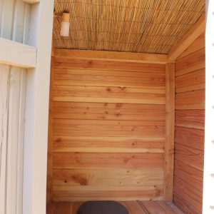 Cabane en bois avec un intérieur chaleureux et un siège en bois, idéal pour un séjour unique.