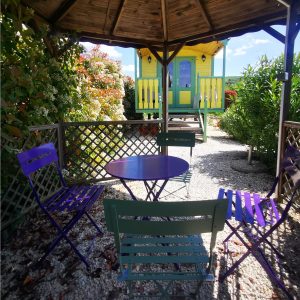 Hébergement insolite en Auvergne-Rhône-Alpes : charmante cabane colorée sous un abri.
