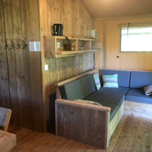 Hébergement insolite en bois avec un coin salon confortable et lumineux.