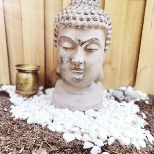 Hébergement insolite en Provence-Alpes-Côte dAzur avec statue de Bouddha et galets blancs.