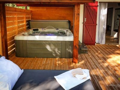 Hébergement insolite en Midi-Pyrénées avec jacuzzi sur une terrasse en bois.